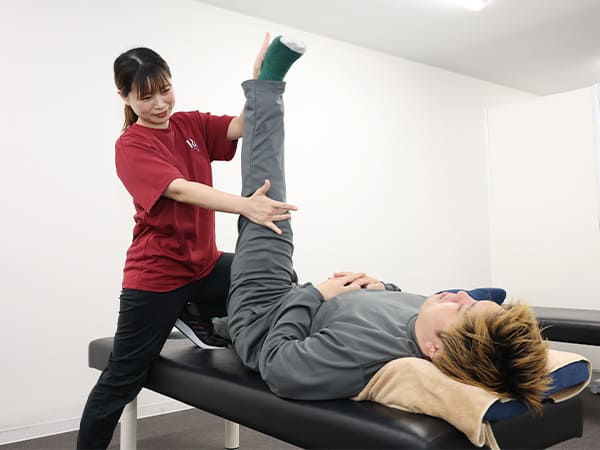 股関節の動きを整える施術の様子
